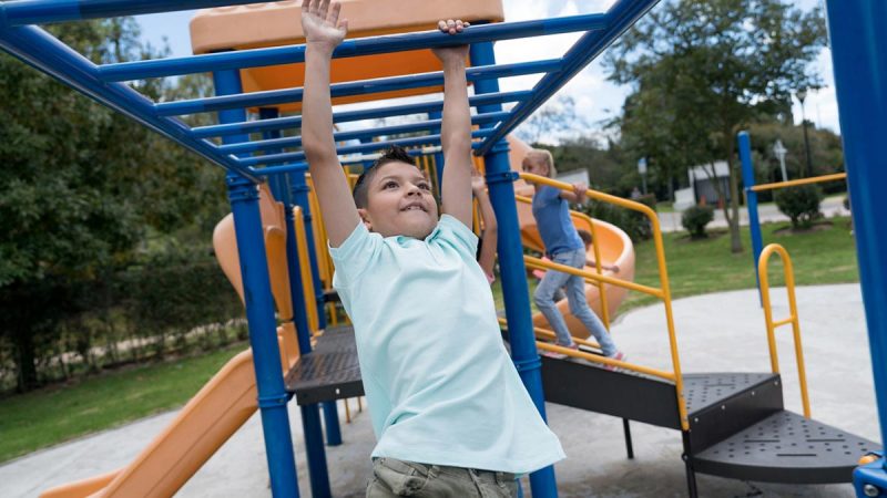 Young boy climbing on monkey bars