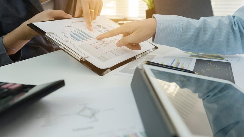 Investor executive discussing plan financial graph data on office table with laptop and tablet, finance, accounting, investment, meeting.