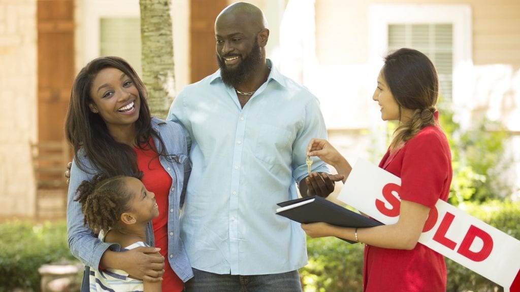 Happy young family accepting the keys to their new home