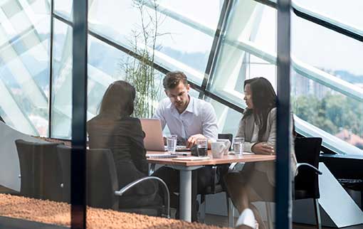 Business people in a glass-walled conference room having a meeting