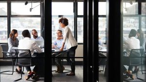 Underwriters having a conference in a meeting room with glass walls