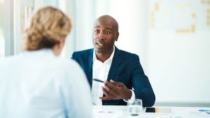 Underwriter educating a young professional at a table