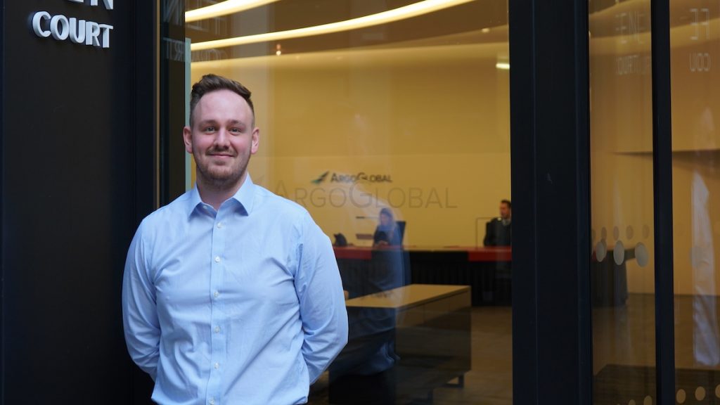 Employee standing in front of ArgoGlobal office