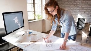 Female designer in office working on architects project