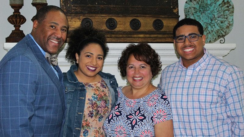 Family of four smiling in a group